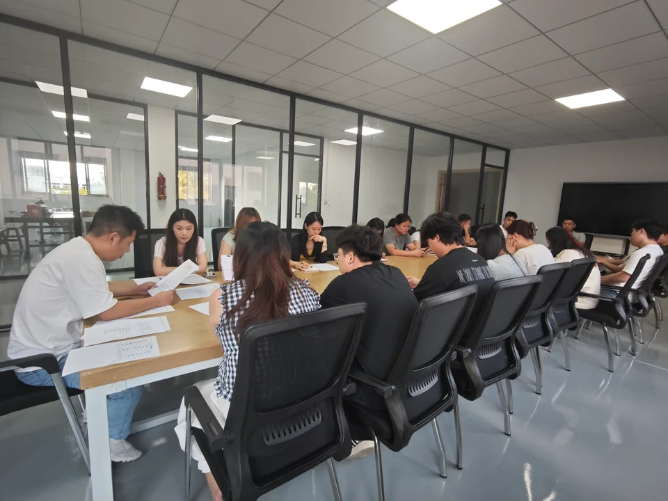 YiTuo colleagues meeting around a table with paperwork in the office.