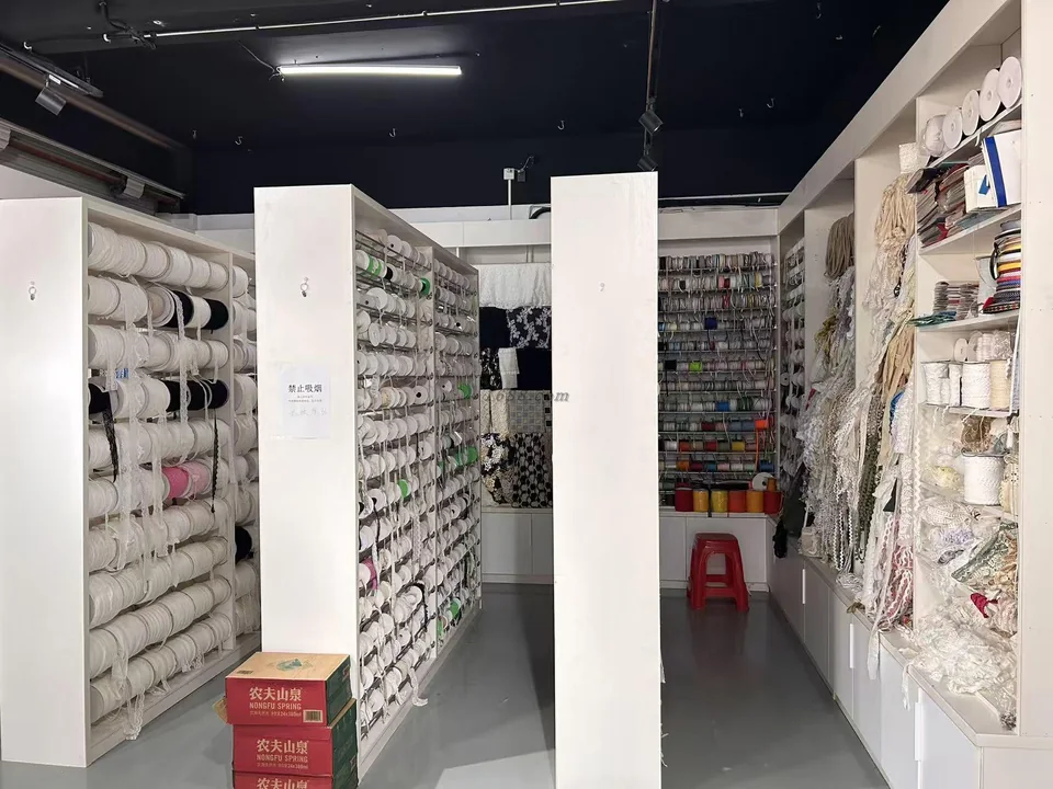 Des rangées de rouleaux de garnitures et d’échantillons suspendus sur des étagères blanches dans un showroom.
