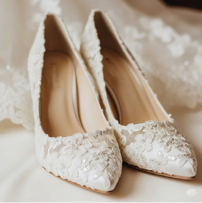 Weiße spitze Schuhe mit floraler Spitzenverzierung Weiße spitze Schuhe mit floraler Spitzenverzierung