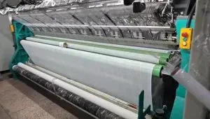 Hochgeschwindigkeits-Webmaschine für Spitzenborten im Betrieb einer modernen Spitzenfabrik, die präzise und effiziente automatisierte Spitzenproduktion zeigt.