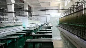 Wide view of a modern factory interior featuring rows of automated embroidery machines used for high-volume lace production and textile manufacturing. Wide view of a modern factory interior featuring rows of automated embroidery machines used for high-volume lace production and textile manufacturing.