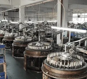 Vista general de una gran instalación de producción de encaje de hilo de algodón con trabajadores cualificados y maquinaria moderna.