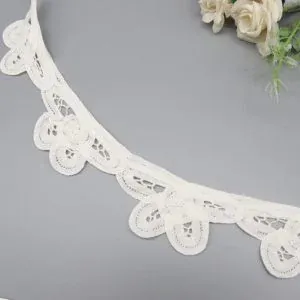 Detailed shot of embroidered pure cotton eyelet border lace showing floral motifs and sturdy edging for long-lasting trim use.
