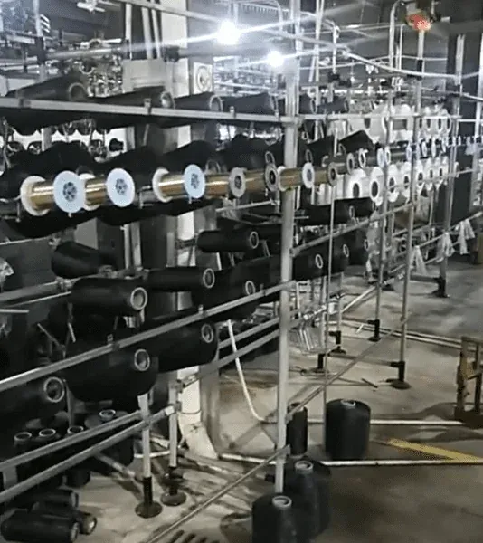 Wide view of automated embroidery and ribbon-weaving equipment making corded borders and grosgrain ribbon trims, showing custom colors, widths, and rapid sampling services. Wide view of automated embroidery and ribbon-weaving equipment making corded borders and grosgrain ribbon trims, showing custom colors, widths, and rapid sampling services.