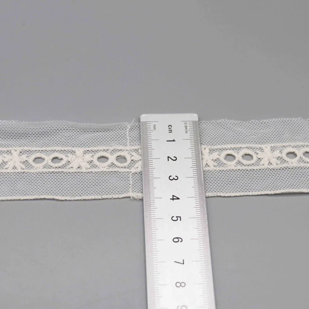 Règle placée verticalement sur le galon pour montrer sa largeur exacte de 4cm