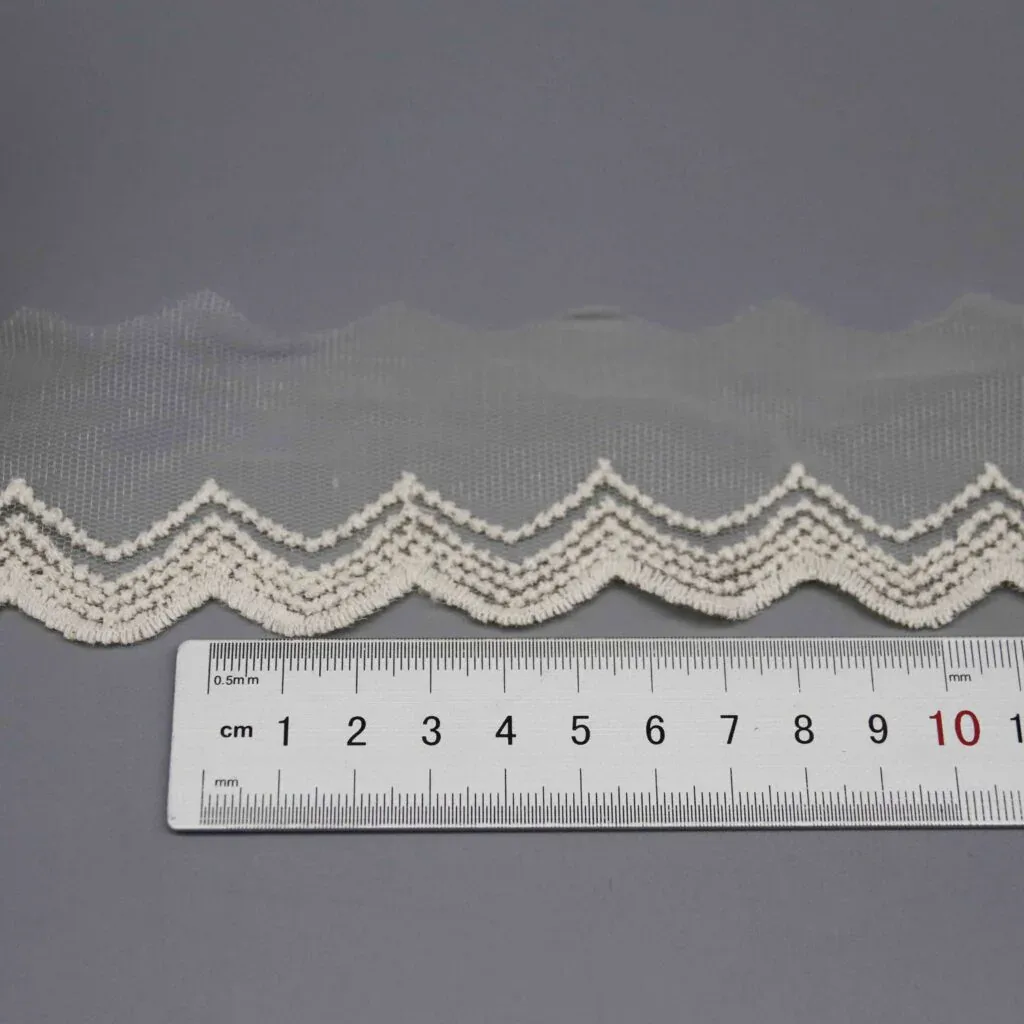 Ruler laid vertically across the lace trim showing the exact 5.5cm width measurement