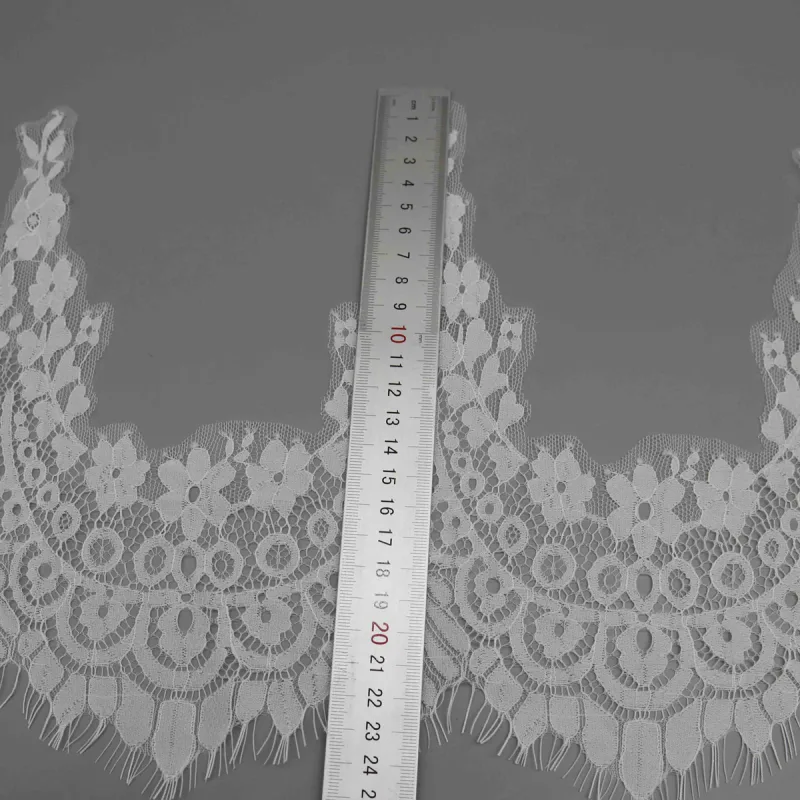 A vertical ruler along the full height of a white lace peak and its lower fringe.