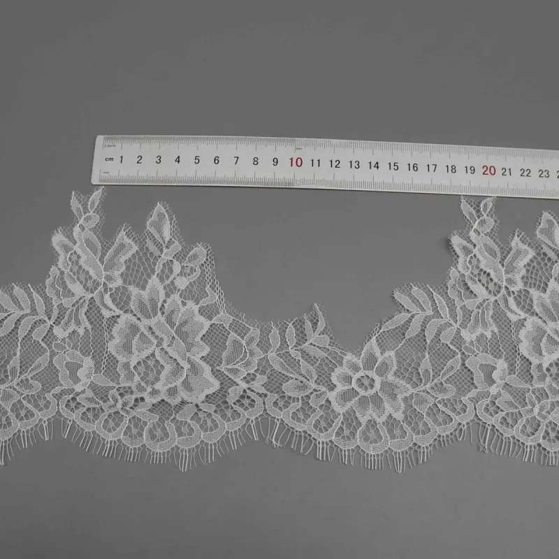 A horizontal ruler above two leafy motifs in a white floral lace strip.