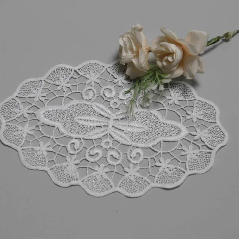Ein weißes ovales Spitzenstück auf Grau mit cremefarbenen Rosen entlang des oberen Rands.