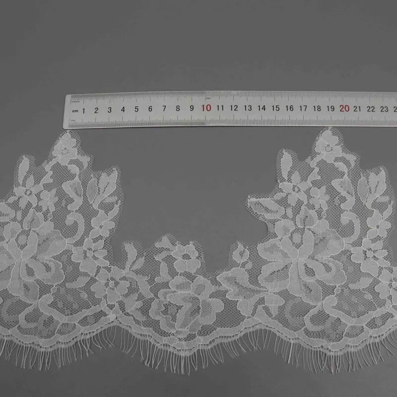 A horizontal ruler showing the repeat between tall leafy motifs in white lace.