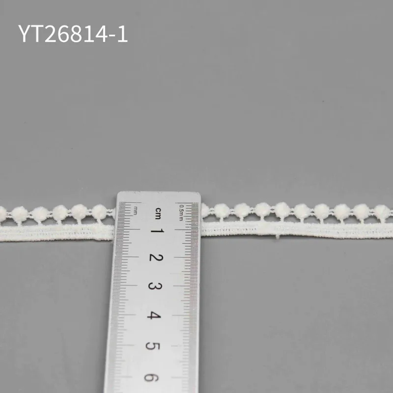A ruler placed across the wider white pompom trim labeled YT26814-1.