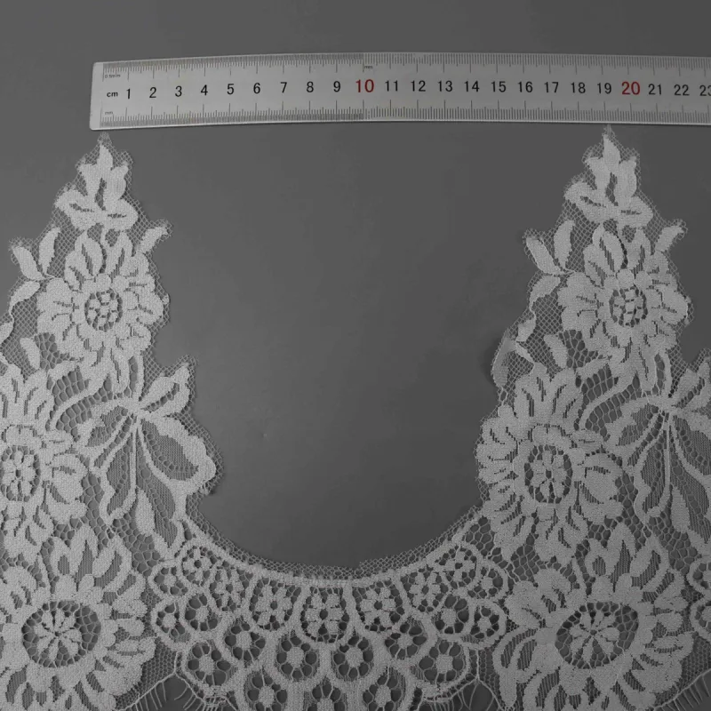 A horizontal ruler over the gap between two tall floral peaks in white lace.