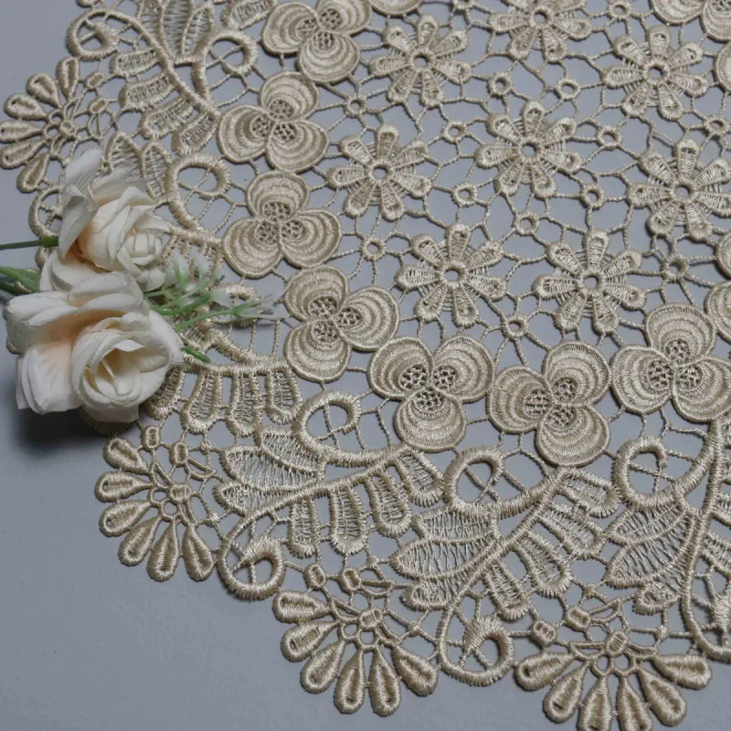 Detail einer beigen Spitzendecke neben cremefarbenen Rosen mit kleinen mittleren Blumen und äußerem Blattmuster.