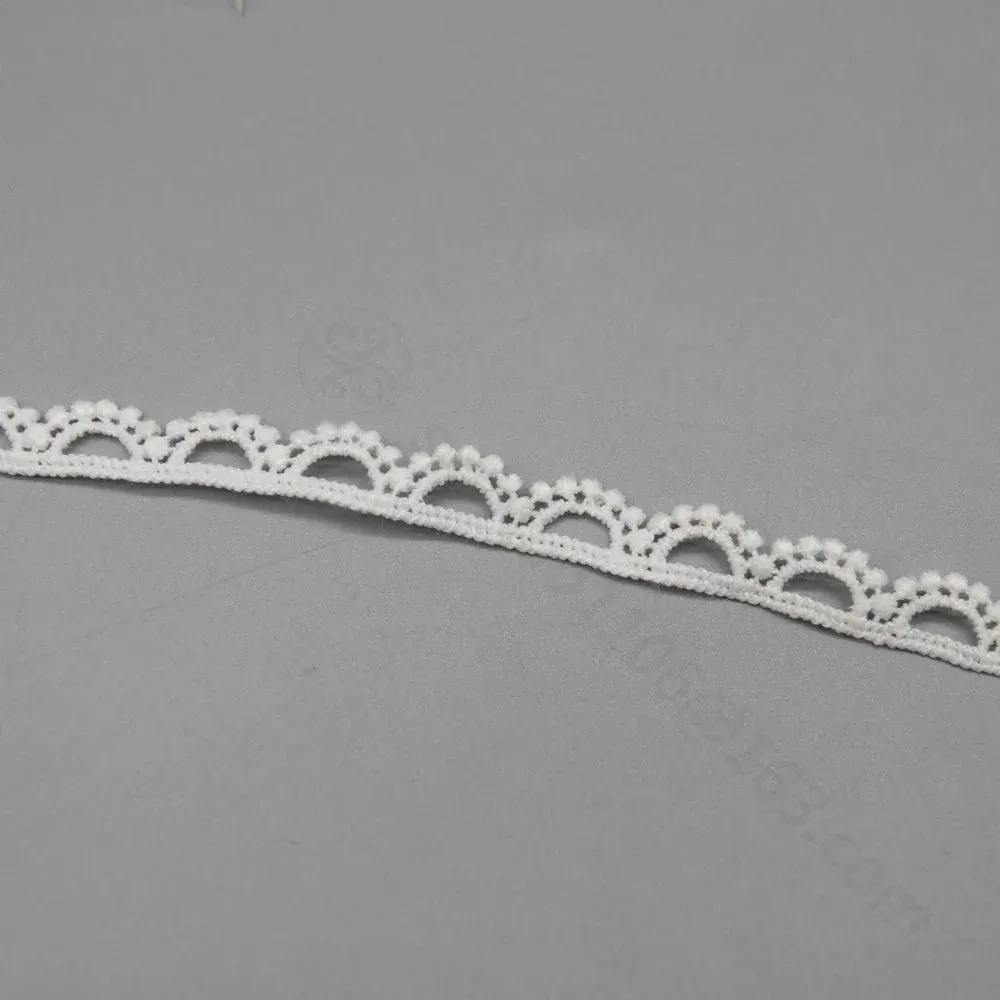 Une longueur droite de galon de dentelle blanche avec de petits festons en éventail. Une longueur droite de galon de dentelle blanche avec de petits festons en éventail.