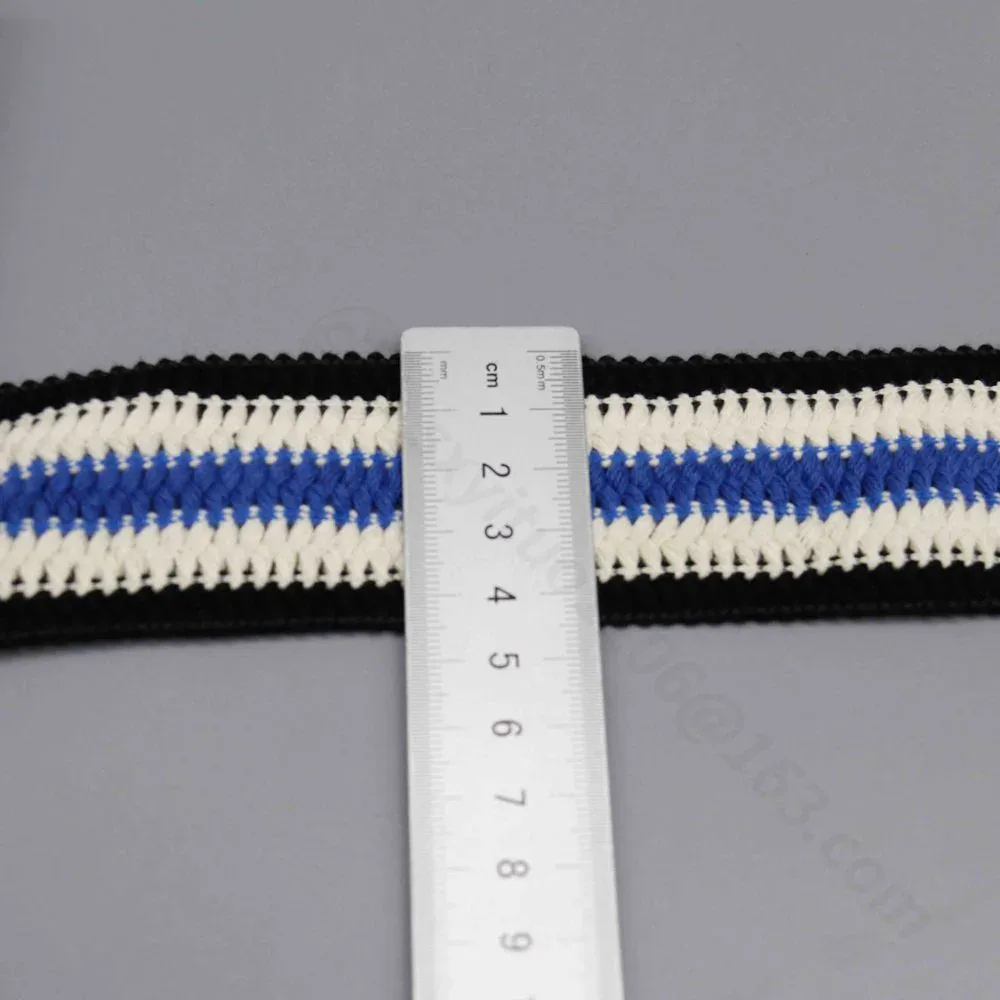 A ruler placed across black, white and blue striped trim. A ruler placed across black, white and blue striped trim.