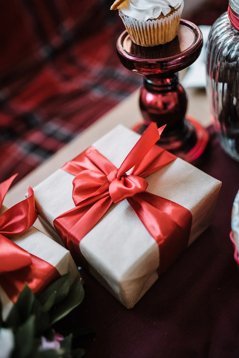 Cinta roja atada alrededor de una caja de regalo envuelta, con un lazo y extremos largos.