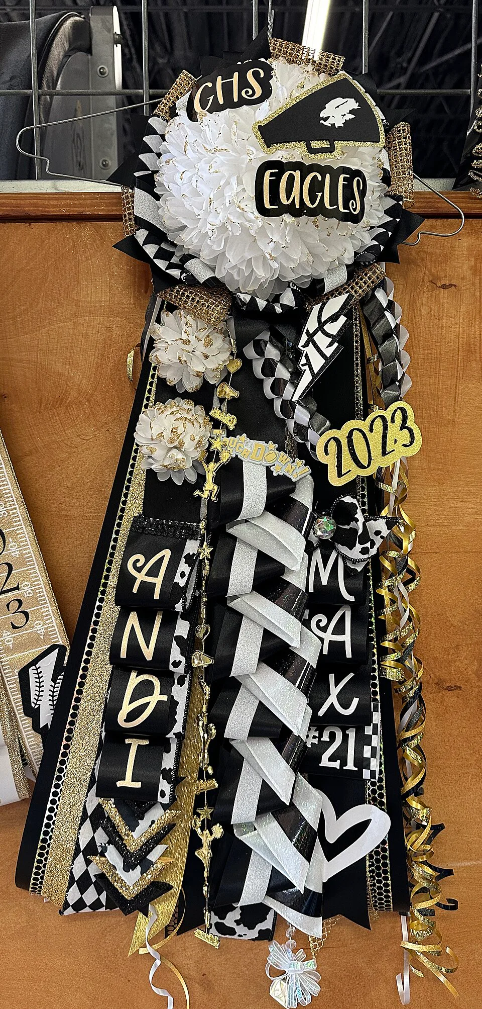 Un distintivo de homecoming de Goldthwaite High School combina cintas rectas, trenzas y lazadas. Diseño de L & L Spirit Co.