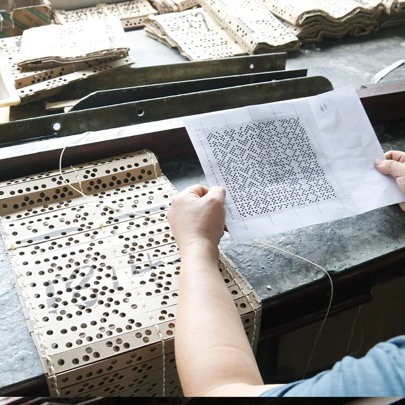 A paper pattern held above the punched cards