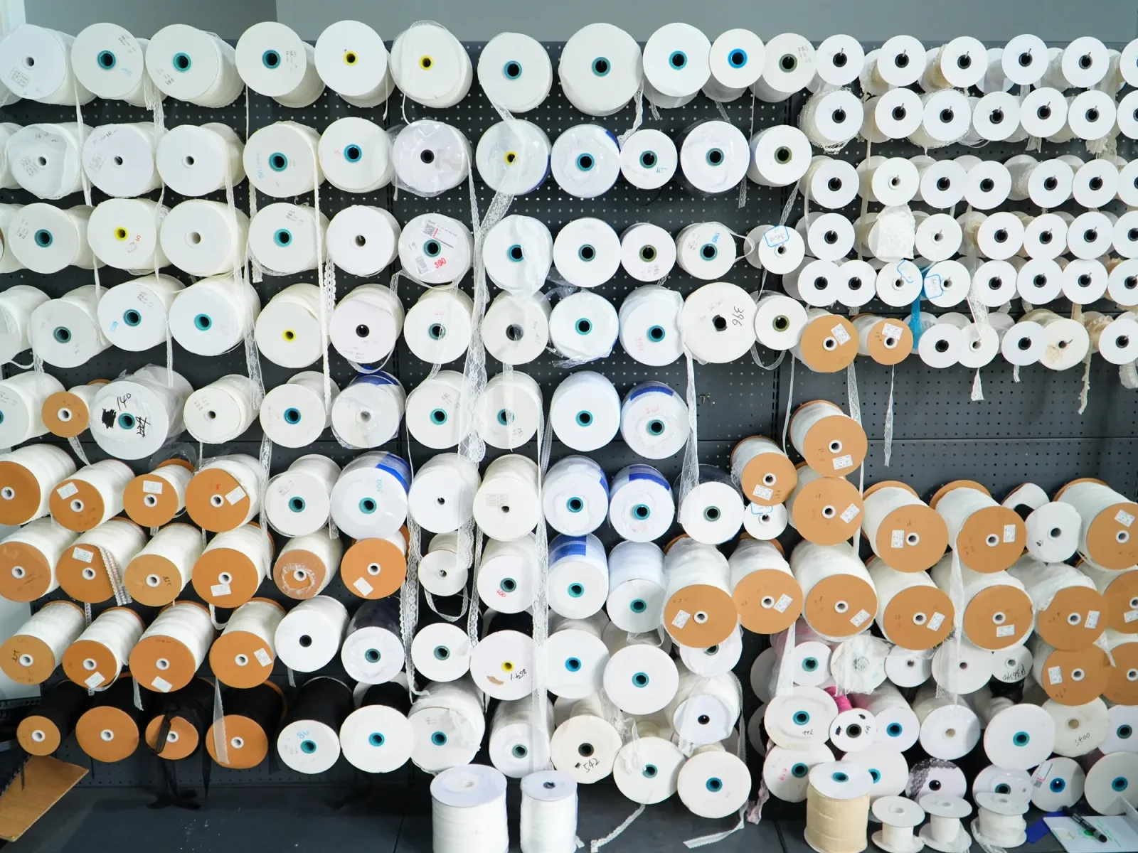 Rouleaux d’échantillons de galons Rangées d’échantillons de galons étroits enroulés sur des bobines blanches et en carton