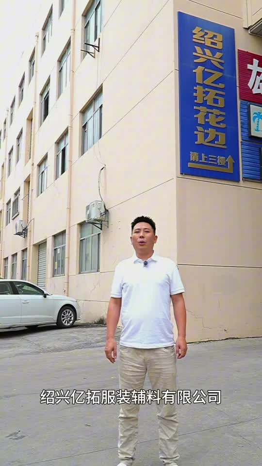 Guofu Gan devant l’usine YiTuo, présentant l’entreprise