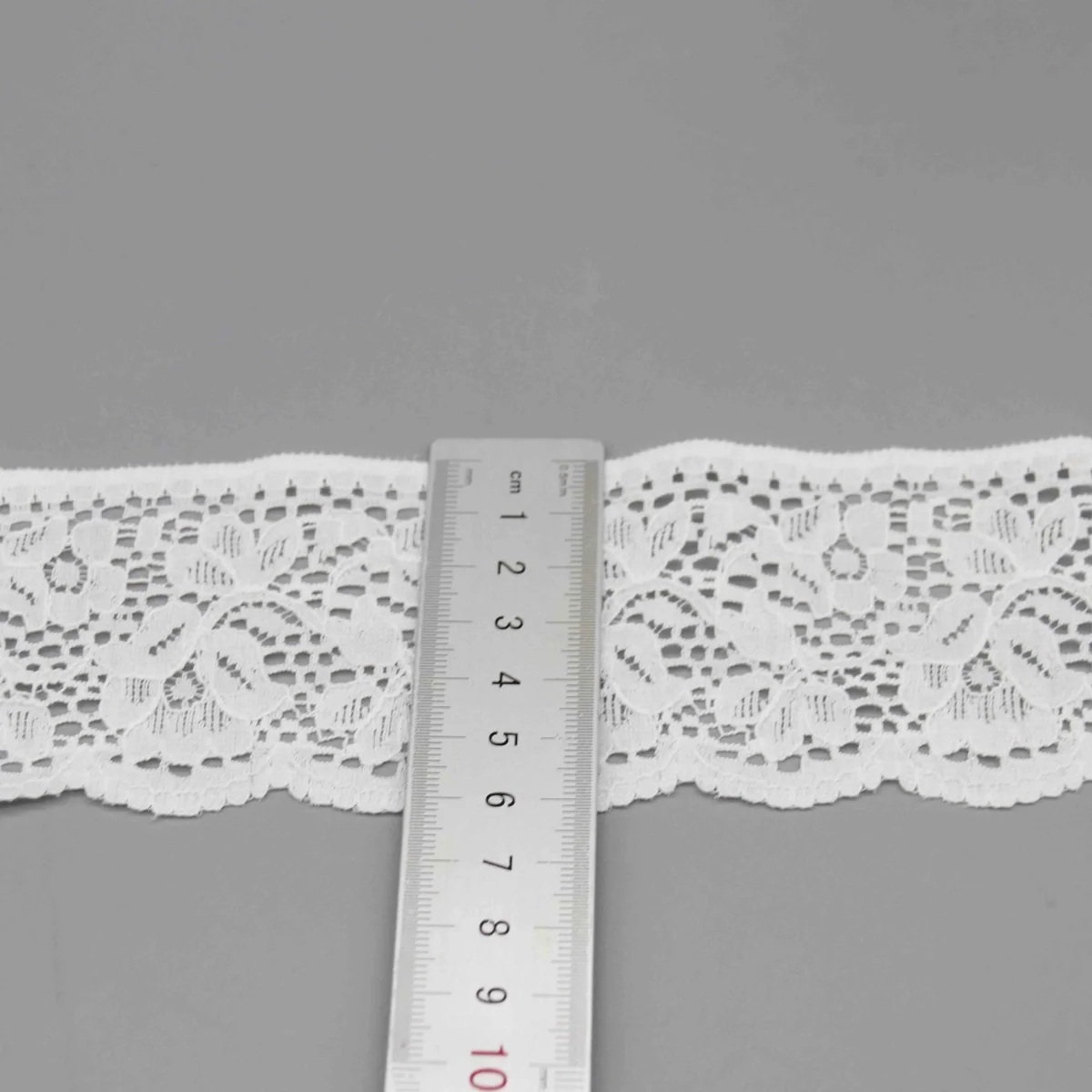 A Repeating Floral and Foliage Pattern On A Net Galloon Lace Trim for Lingerie