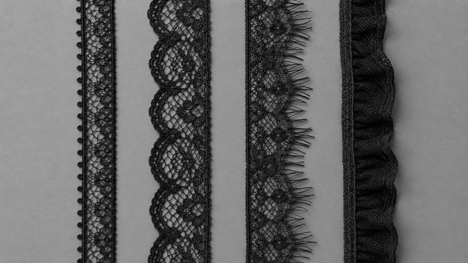 Four narrow black stretch lace edge samples showing picot, scalloped, eyelash, and plush constructions