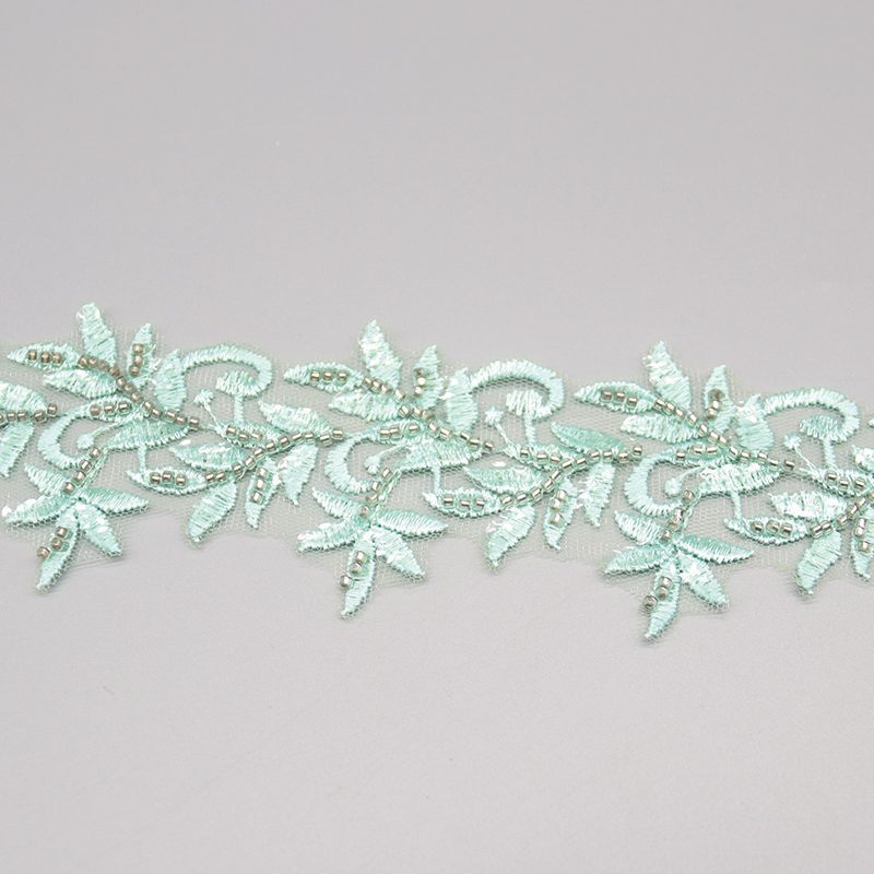 Light green embroidered lace featuring beaded leaf motifs, adding a delicate and romantic touch to garments.