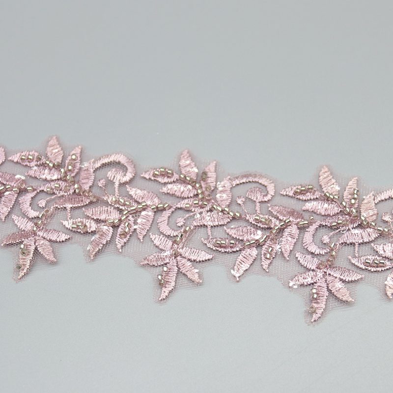 Sophisticated white and silver beaded lace trim, specially designed for bridal gowns and formal dresses. Alt Title: Lace Fabric Rolls Display