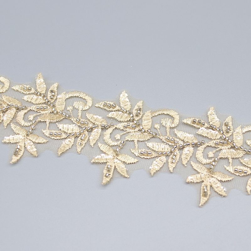 Detailed close-up showing fine embroidery stitches and beadwork, highlighting the quality of the handmade lace trim.