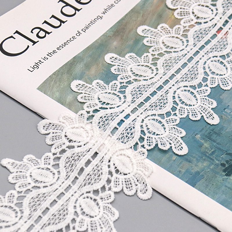 Sample card displaying multiple widths of water soluble and chemical lace ribbons with scalloped borders and color variations.