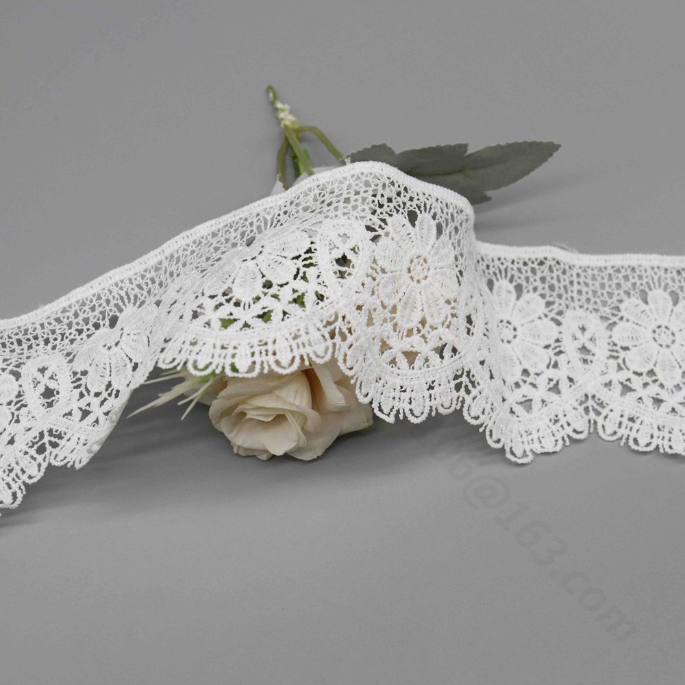 Detailed view of new milk silk polyester water-soluble lace trim in clean snow white, highlighting refined hollow Guipure technique with vivid floral-geometric designs, multi-tiered 3D structure, and graceful wave-shaped edges; versatile moderate width for dress collars, skirt trims, and bag embellishments.