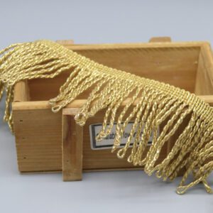 Top-down view of metallic gold fringe trim showing uniform strand length and wave pattern