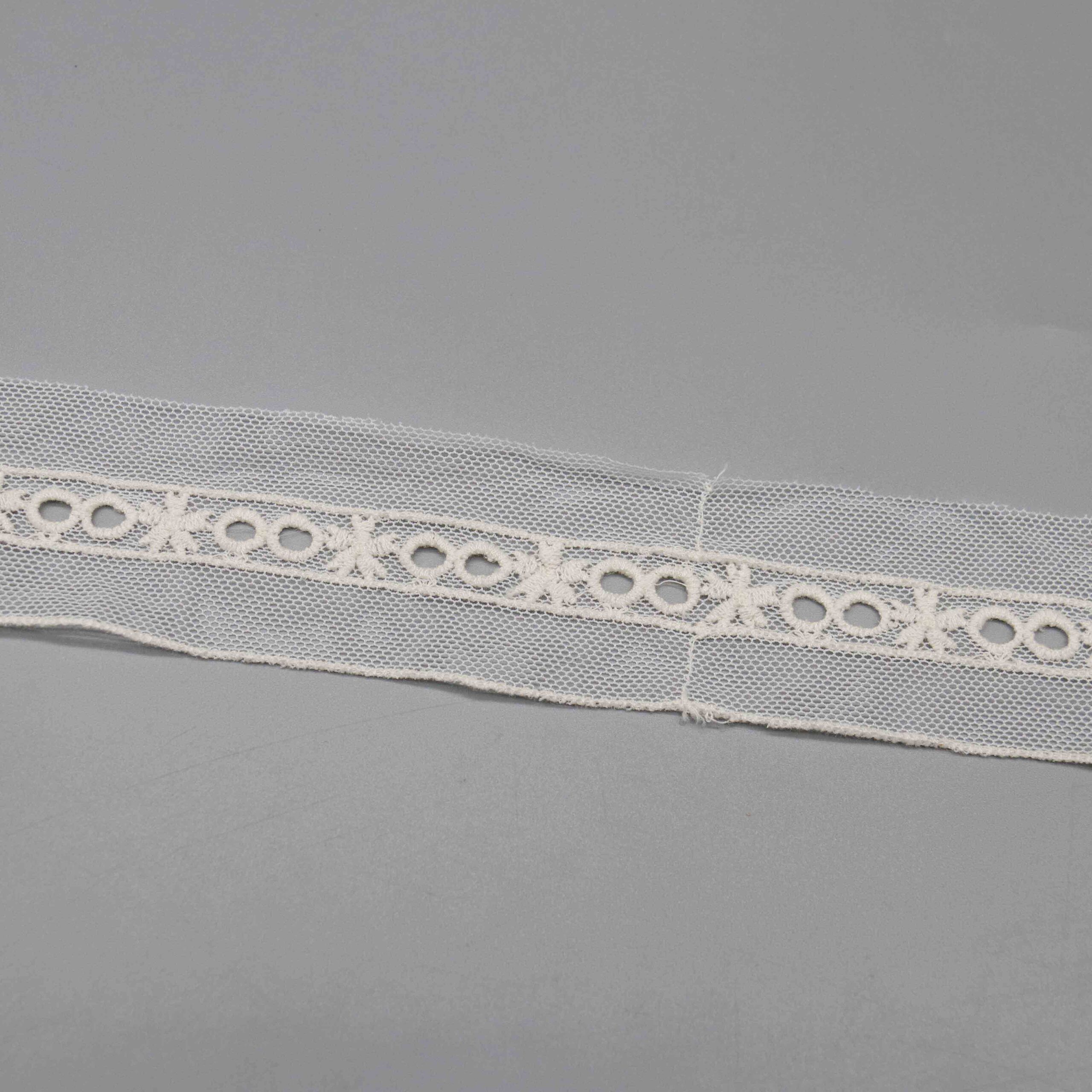 Angled shot capturing the sheer mesh texture and raised embroidery definition of the eyelet pattern.