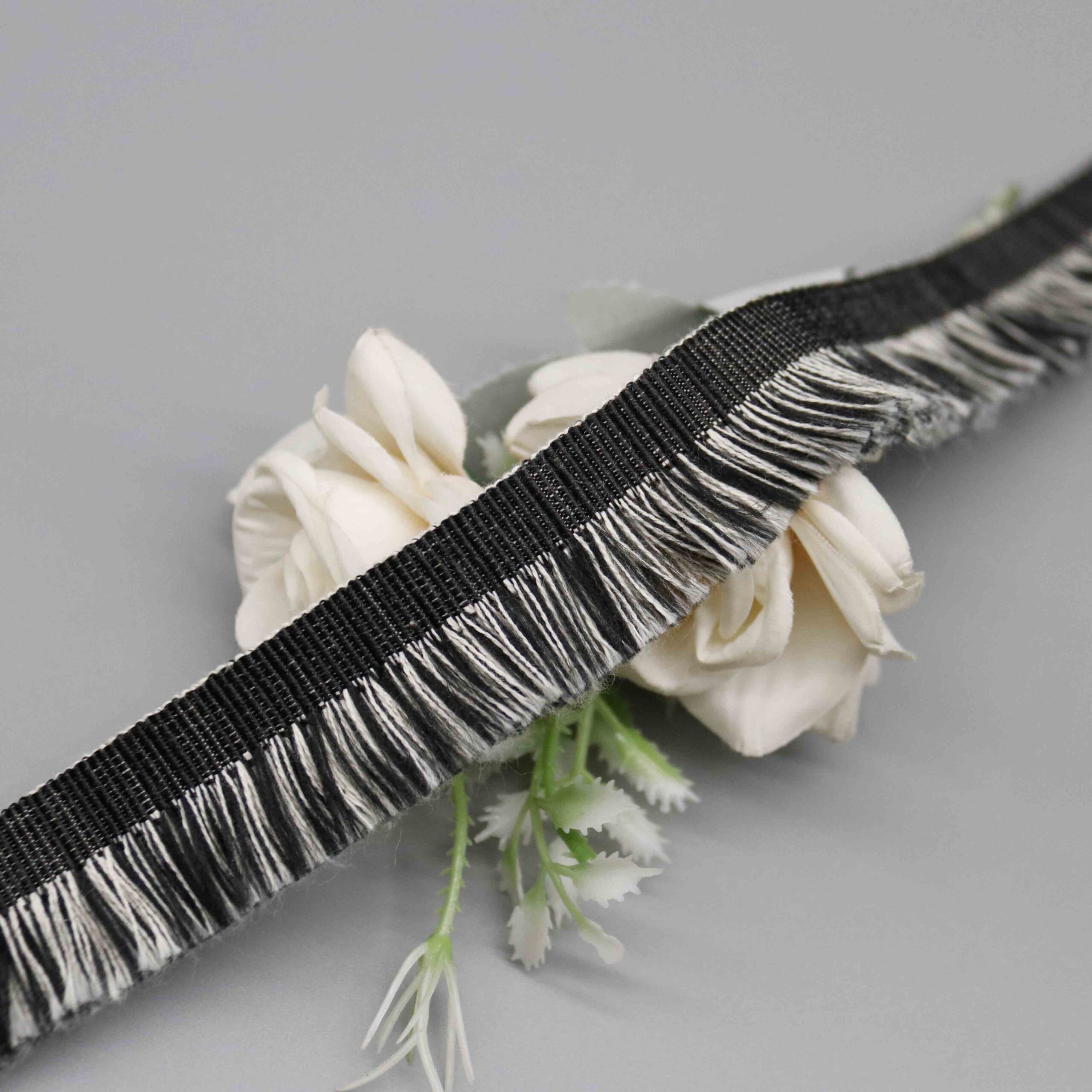 High-resolution detail showing the dense woven twill header band construction in charcoal black.