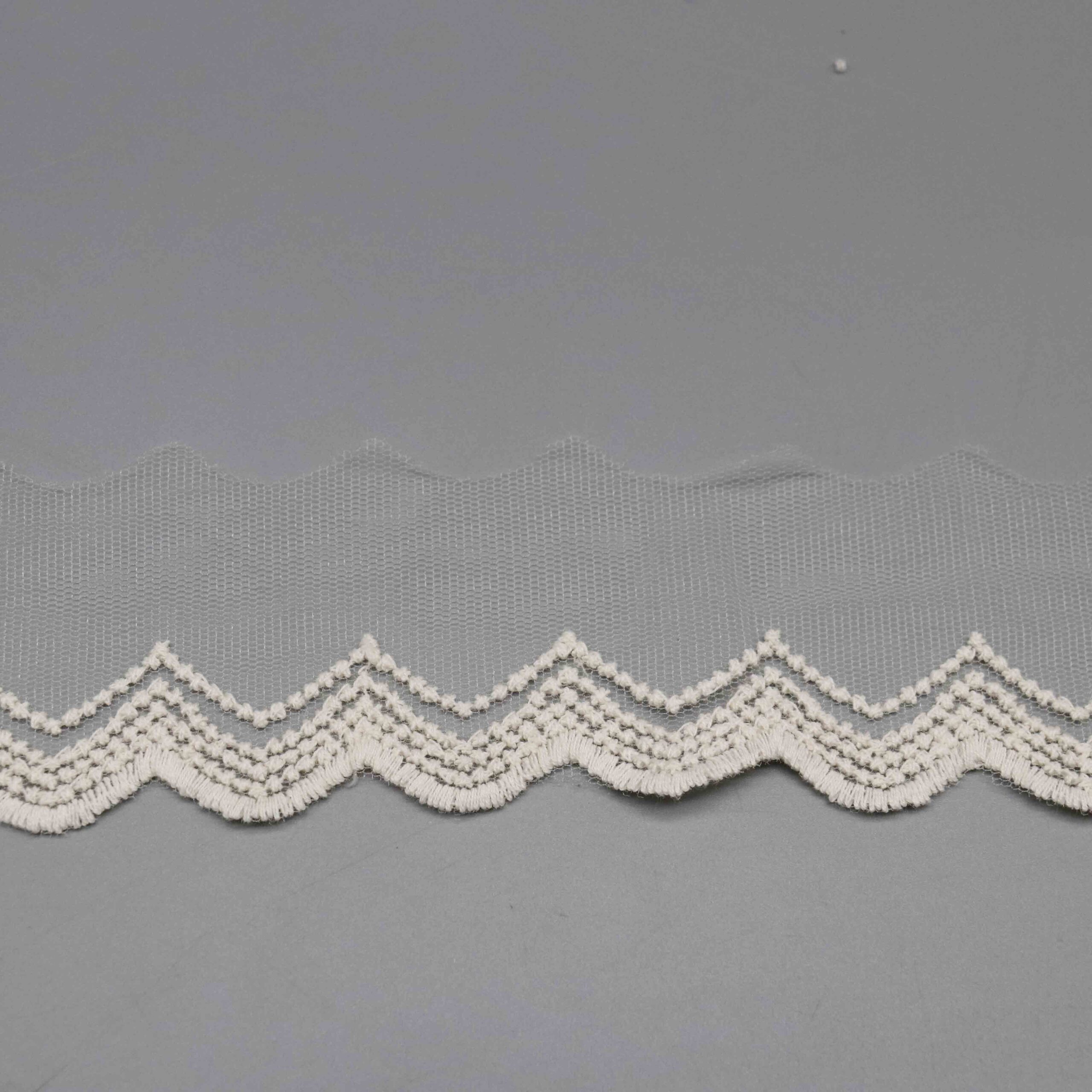 Backlit shot demonstrating the hexagonal mesh transparency and embroidery density contrast.