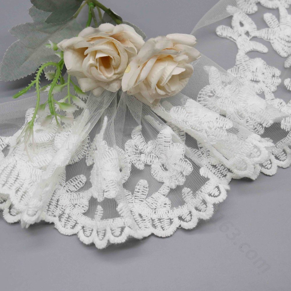 Backlit demonstration of tulle openness and floating see-through characteristics through embroidered fabric.