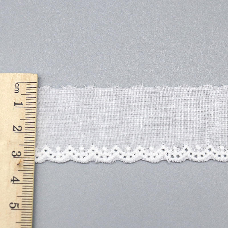 A close-up studio image of a 3cm wide, 100% cotton lace edging with a mini-scalloped border, shown next to a ruler for scale