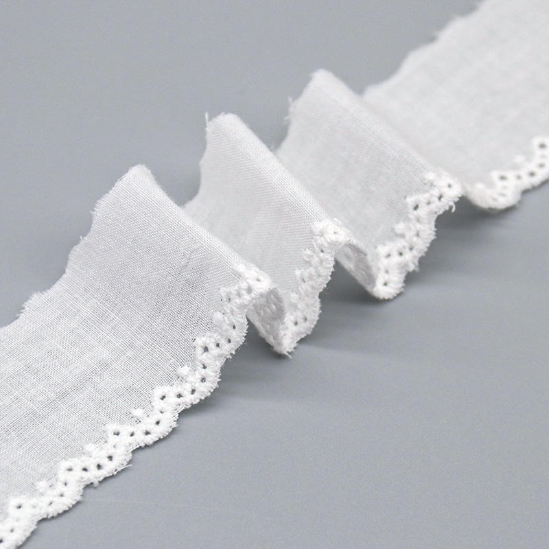 A close-up studio image of a 3cm wide, 100% cotton lace edging with a mini-scalloped border, shown next to a ruler for scale