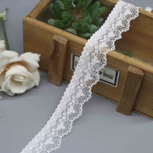 A close-up studio shot of a 2.5cm wide narrow stretch lace in white, showing its delicate floral pattern and symmetrical scalloped edges.