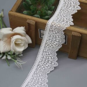 A studio photo of a 4.5cm wide white scalloped edge stretch lace, highlighting its asymmetrical design with a straight heading and a decorative fan-scallop edge.