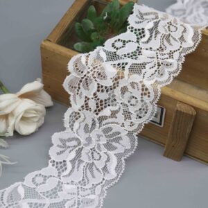 A product image of a 7cm wide white floral stretch lace, highlighting its intricate corded detail and scalloped edges.