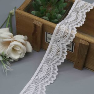 A studio product shot of a 3.3cm wide white floral stretch lace trim, showing its asymmetrical design with a straight sewing edge