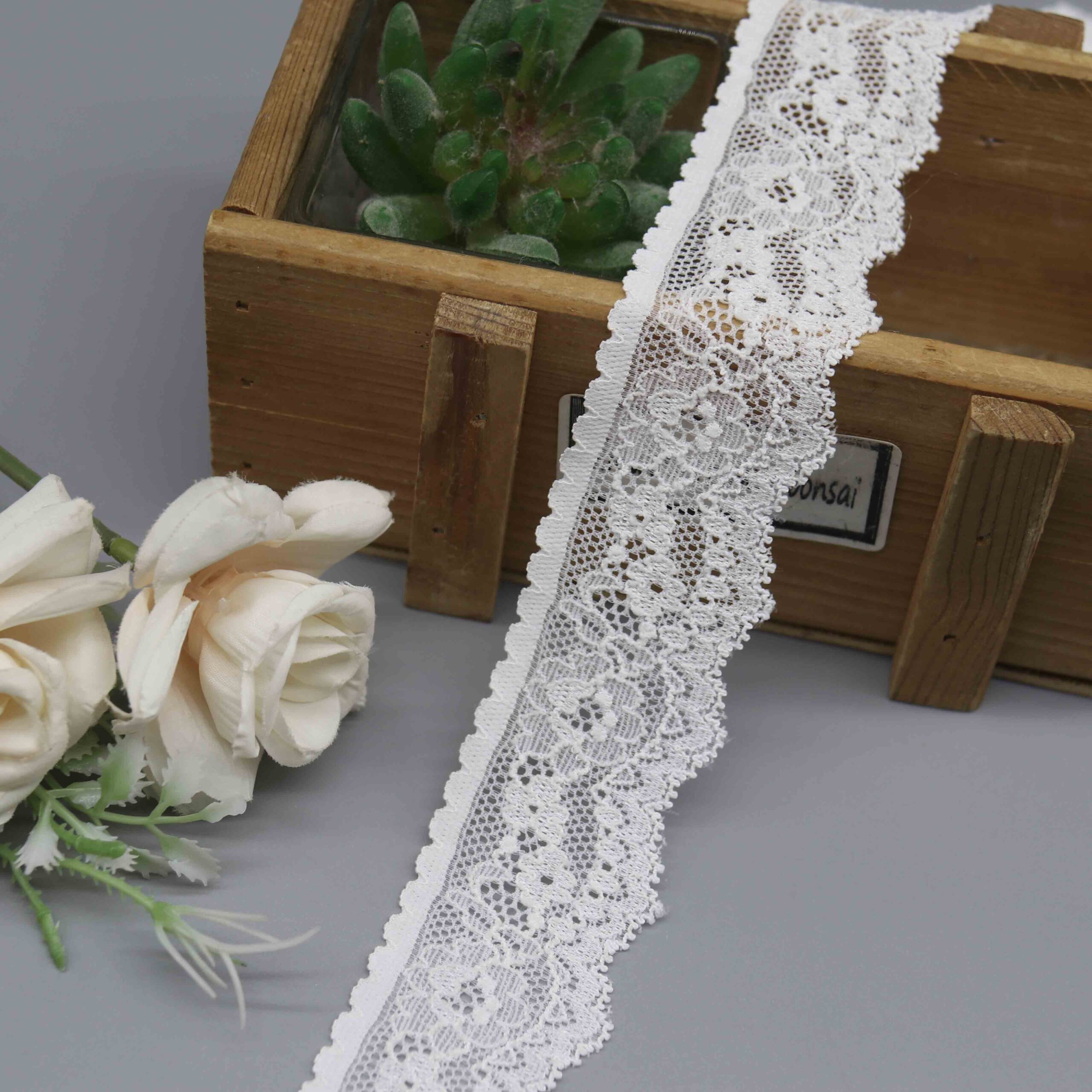 studio photo of a 3.6cm white stretch lace for lingerie, model HDL-1421, showing its fine floral pattern and single scalloped edge