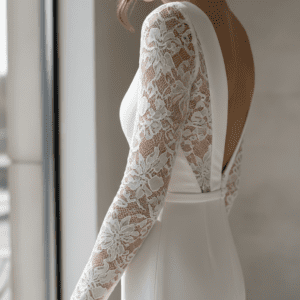 Close-up of a modern minimalist bridal gown featuring intricate white nylon spandex elastic lace sleeves and side panels.
