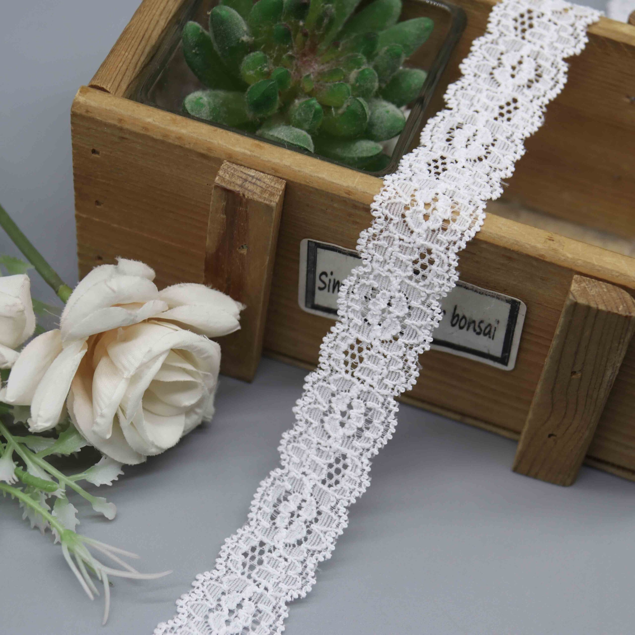 a 2.3cm white galloon stretch lace with a symmetrical floral medallion pattern.