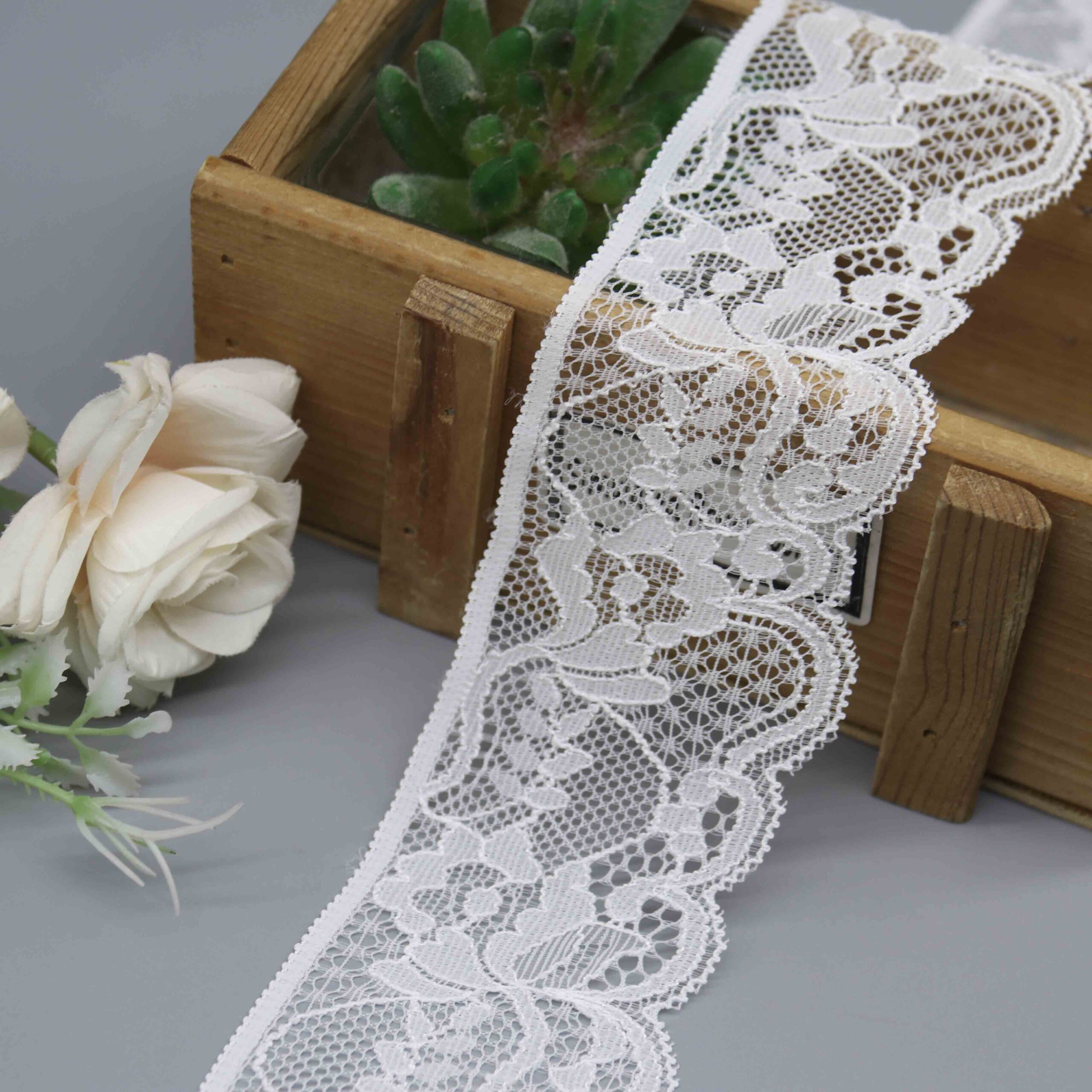 a 5.2cm wide white scalloped stretch lace with a classic floral design.