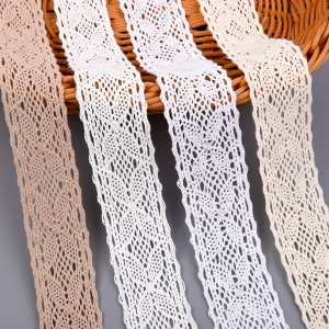 Assorted colors of cotton lace trims with intricate crochet patterns displayed on a woven basket.