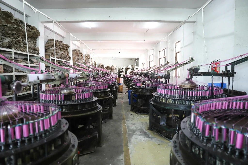 Technician preparing yarns and lace bobbins for weaving machine setup.