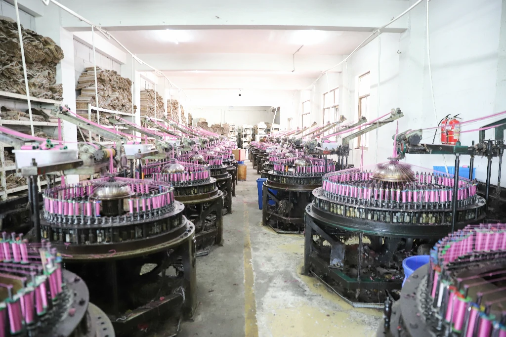 Modern lace loom operated by a technician in a busy textile plant.
