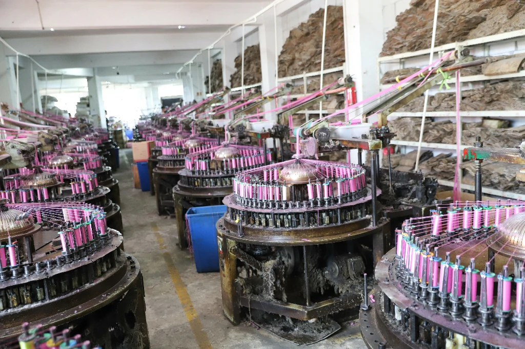 Textile factory worker seated at a lace production station with baskets of materials.